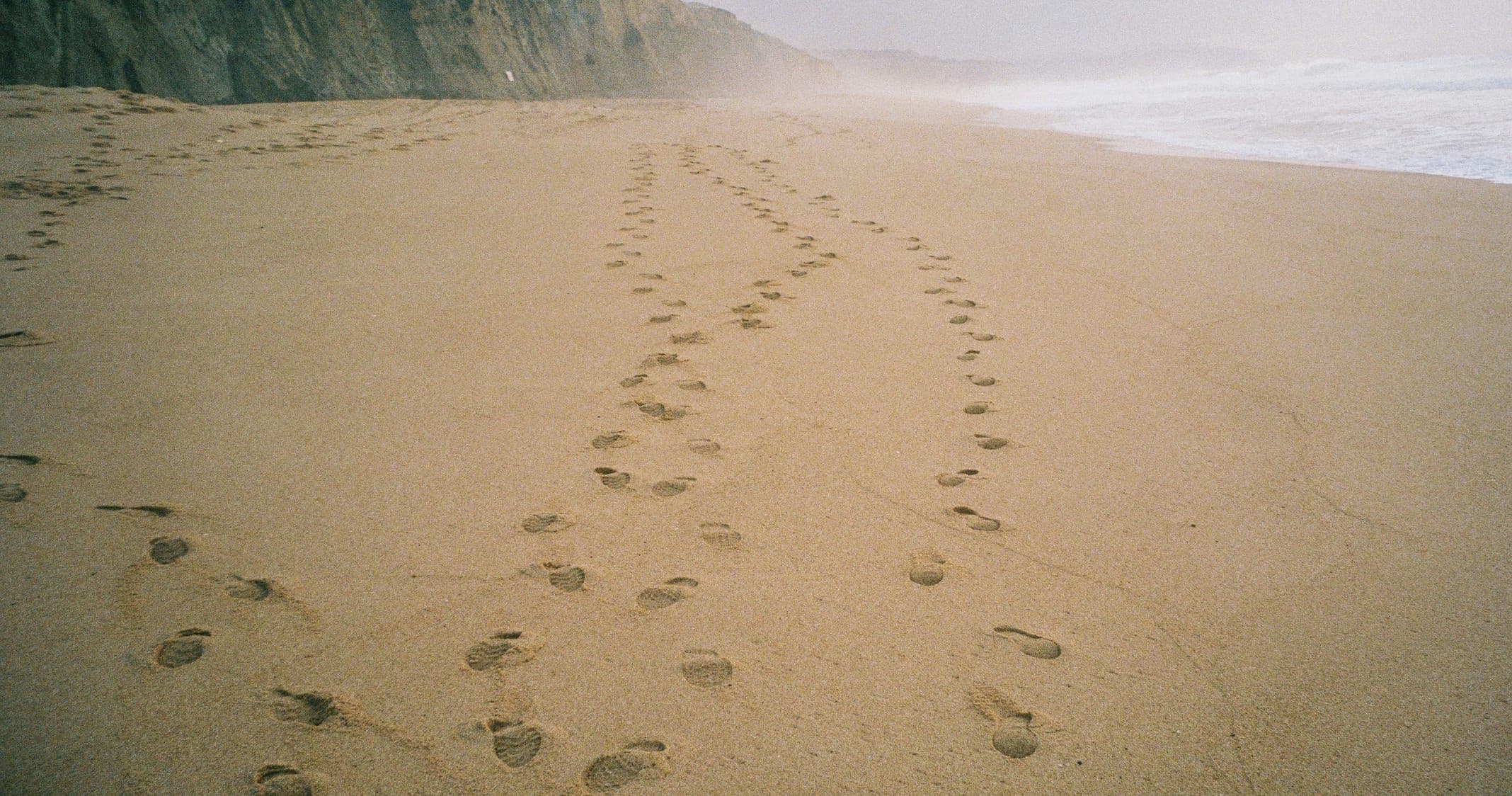 Fotsteg på en sandstrand.